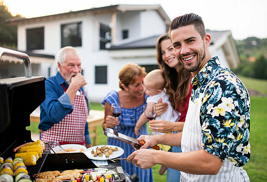 Haus-Familie-Wohnen-Garten-Serie-30-06 Familie beim Grillen im eigenem Garten